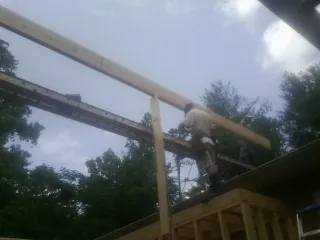Carpenter setting a ridge beam over a new addition frame — Ice Dam Removal by Roofing Brothers in Roseburg