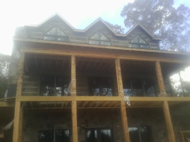 Dormers and porch framing on a large log home under construction — Roof Coating work by our crew in Roseburg