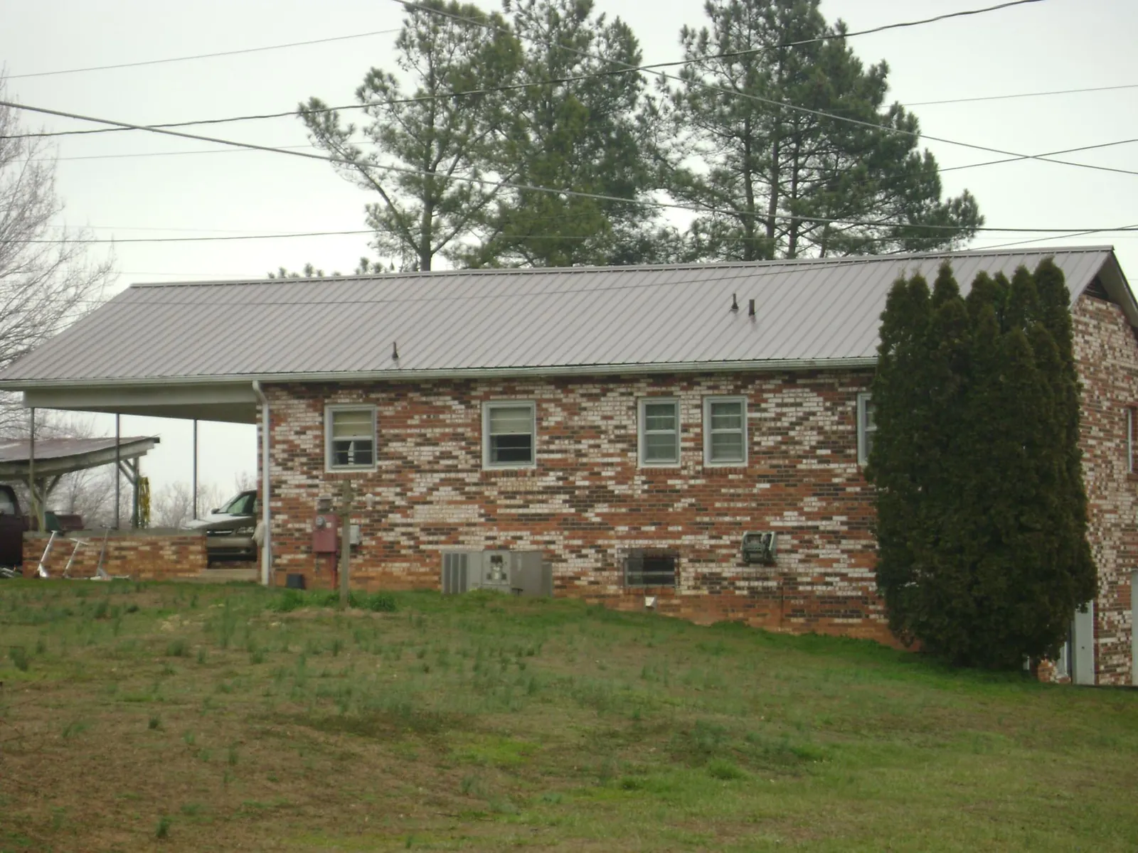 Gray metal roof on a brick split level home with a carport in Roseburg