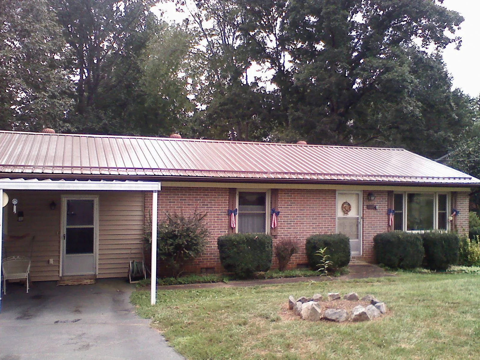Bronze metal roof and carport on a brick ranch home — Roof Repair work by our crew in Roseburg